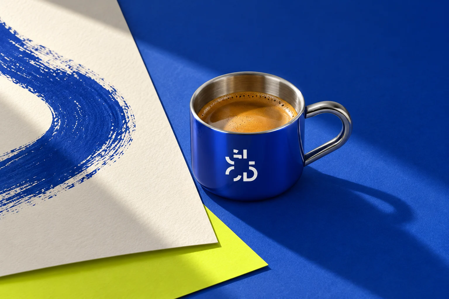 Blue Golconda coffee cup beside a painted brushstroke on textured art paper with a lime accent.